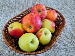 Green and red apples in a basket, close-up