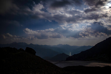 A serene valley illuminated by a full moon. A breathtaking view of snow-capped mountains