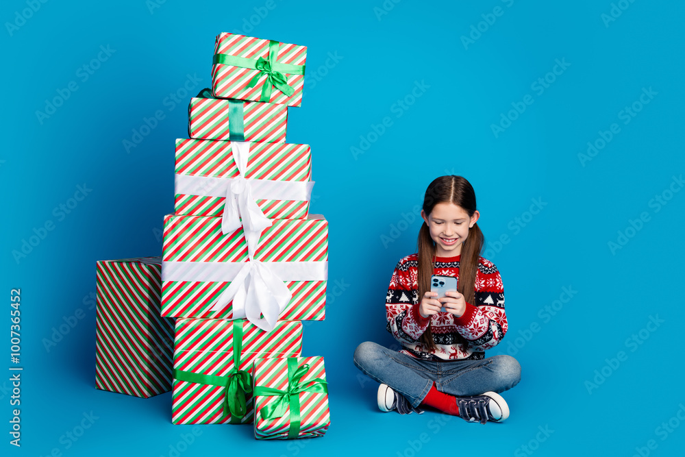 Poster Photo of funny nice girl wear ugly print sweater sit floor christmas time pile stack gifts isolated on blue color background