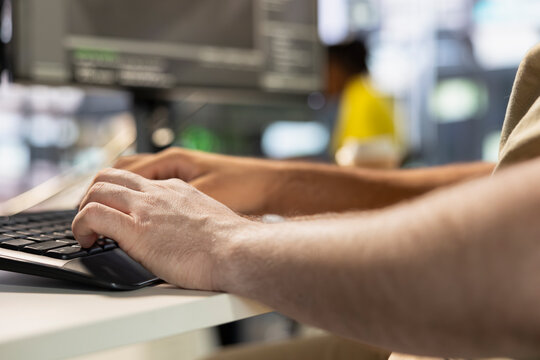 Programmer types on keyboard, testing company software to minimize occurrence of bugs, identifying bottlenecks. Close up of man writing clean, efficient code in programming language to reduce glitches