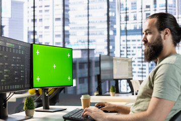 Technician conducting code review on isolated screen computer to fix bugs, identifying performance...