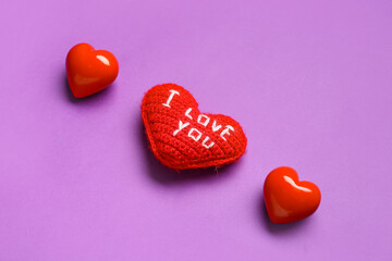 Composition with text I LOVE YOU and hearts for Valentine's Day on purple background