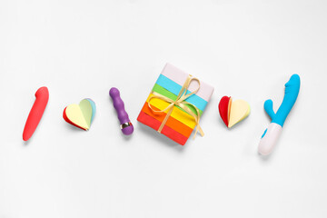 Rainbow LGBT gift box with paper heart and sex toys on white background. Valentine's day celebration
