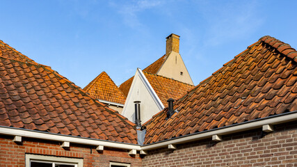 Panorama of picturesque vibrant sunlight illuminated rooftops of Hanseatic city Zutphen in The Netherlands against a blue sky. Historic architectural detail of Dutch town.