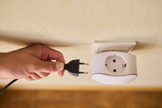 Hand Plugging in an Electrical Device for Essential Power Supply and Utility Connection