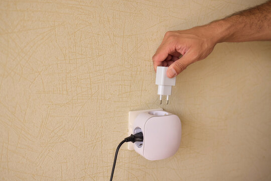 Hand Plugging in an Electrical Device for Essential Power Supply and Utility Connection