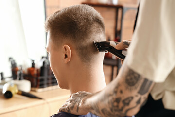 Male hairdresser trimming client's hair in barbershop, closeup