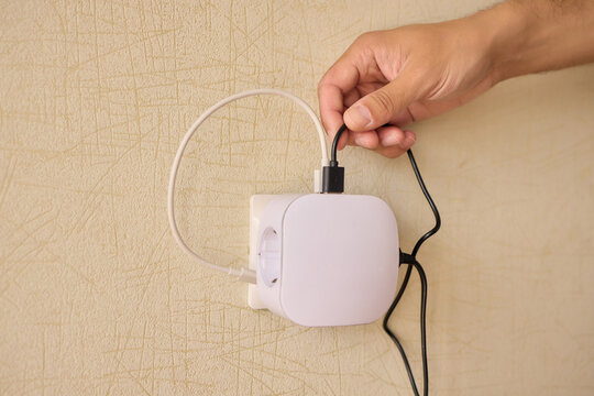 Hand Plugging in an Electrical Device for Essential Power Supply and Utility Connection