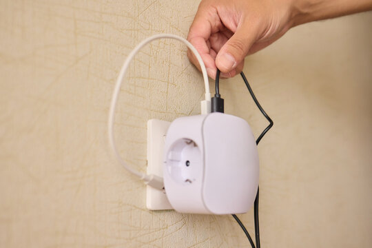 Hand Plugging in an Electrical Device for Essential Power Supply and Utility Connection
