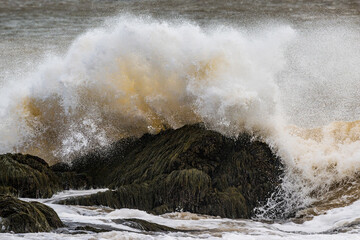Large ocean wave crashing over rocks
