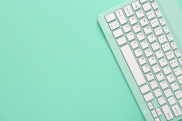 Green computer keyboard on green background. Top view