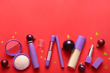 Naklejka premium Composition with decorative cosmetics and Christmas balls on red background