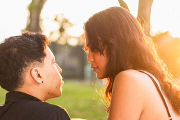 close-up of the profile of the faces of two young Latinos staring into each other's eyes