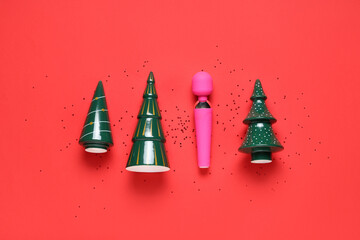 Composition with ceramic Christmas trees and vibrator on red background