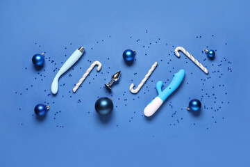 Composition with sex toys and Christmas decorations on blue background