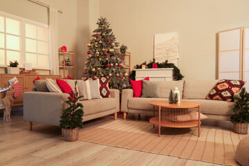 Interior of living room with  grey sofa, Christmas tree and festive decorations at evening