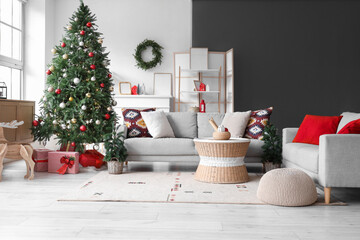 Interior of living room with grey sofas, Christmas tree, gift boxes and festive decorations