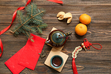 Envelopes with tangerines, cups of tea, fortune cookies and Chinese symbols on brown wooden...