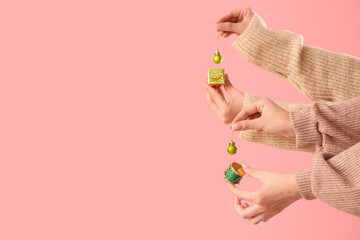 Female hands with beautiful Christmas decorations against pink background