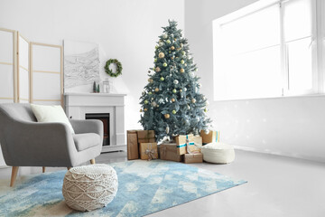 Interior of light living room with fireplace, armchair and Christmas tree