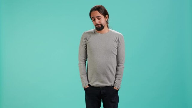 Portrait of troubled man feeling saddened and rattled by bad news, isolated over studio backdrop. Distressed person on the verge of crying, left speechless by troubling events, camera A