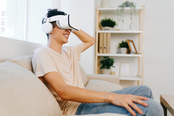 Virtual reality experience, young man enjoying immersive technology while sitting on a comfortable...