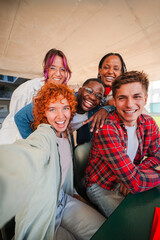 Vertical. Happy group of diverse students taking a selfie together, capturing a moment of...