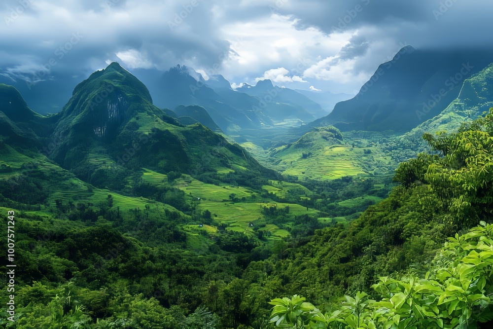 Wall mural Panoramic view of a tranquil valley surrounded by majestic mountains and lush greenery under clouds