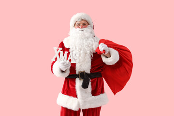 Santa Claus with Christmas bag and word XMAS on pink background