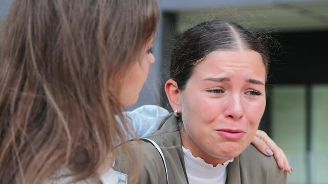 Upset woman sharing her problems with a comforting friend in an emotional , depicting support, empathy, and friendship during a difficult moment. Mental health and relationships. Females trouble