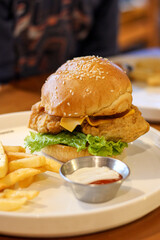 Chicken burger with mayonnaise and french fries.