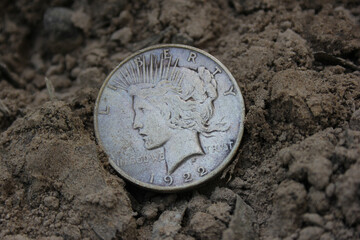 1922 Silver Peace Dollar On Ground in Dirt. Front View