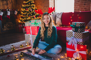 Full size photo of attractive teen girl wrapping gift dressed green christmas outfit day light home...