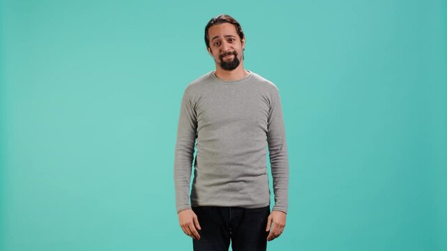 Man shrugging shoulders, expressing uncertainty or helplessness, having troubled facial expression. Person unable to provide assistance to friend, feeling powerless, studio background, camera A