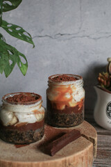 Homemade Banoffee cake made from bananas, whipped cream and a thick caramel sauce with green plant on table. 
