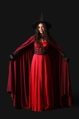 Obraz premium Young witch in hat on dark background