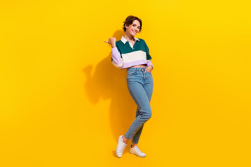 Full length photo of excited pretty woman wear polo shirt showing thumb empty space isolated yellow color background