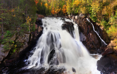 Obraz premium The Chute du Diable with autumn leaf color background in Mont Tremblant National Park, Quebec