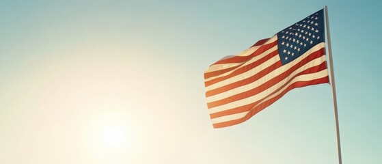 Obraz premium American Flag Waving Against Bright Sunlight and Clear Sky