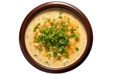 A top-down view of garlic soup in a ceramic bowl, topped with grated cheese and a sprig of parsley, isolated on a white background