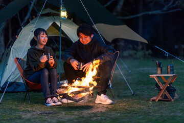 焚き火にあたる男女