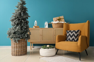 Interior of living room with Christmas tree, commode and armchair
