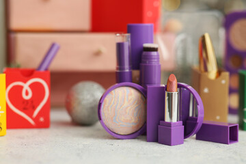 Naklejka premium Makeup products on table against blurred Christmas Advent calendar, closeup
