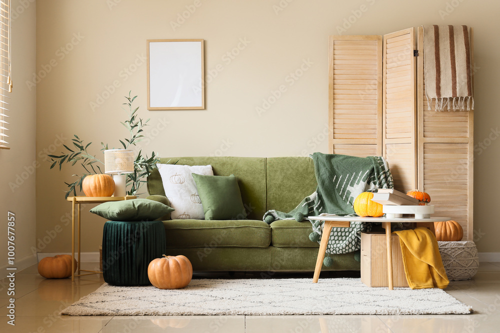 Wall mural Interior of light living room with green sofa, tables and pumpkins