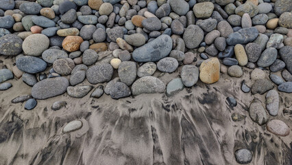 stones scattered on the beach and sand that create beautiful and unique patterns and structures