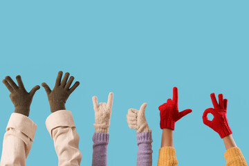 Women in warm gloves gesturing on blue background
