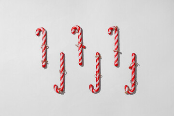 Christmas candy canes with stylish jewellery on grey background