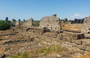 Stone ruins of foundations of western section of basilica used for commercial purposes in ancient Greco-Roman city of Aspendos in Antalya province. Archaeological and historical sights of Turkey