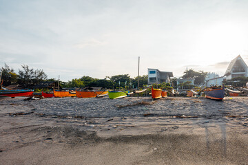 Beautiful fine white sand beach with fishing boats at the shore.