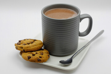 cookies with chocolate chips and a cup with a hot drink on white background
